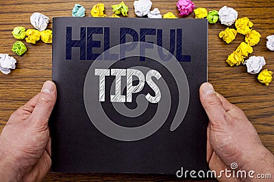 Word, writing Helpful Tips. Business concept for Help in FAQ or Advice, written on notepad notebook book on the wooden wood backgr Stock Photo