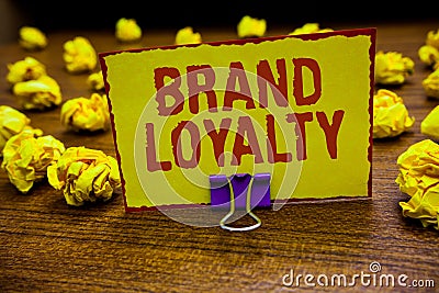 Word writing text Brand Loyalty. Business concept for Repeat Purchase Ambassador Patronage Favorite Trusted Clip holding yellow pa Stock Photo