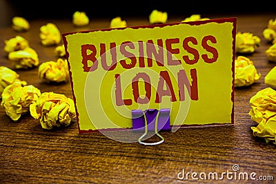 Word writing text Business Loan. Business concept for Credit Mortgage Financial Assistance Cash Advances Debt Clip holding yellow Stock Photo