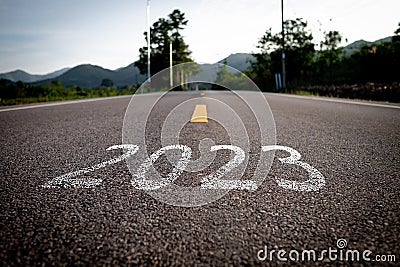 The word 2023 is written on an empty road. Stock Photo