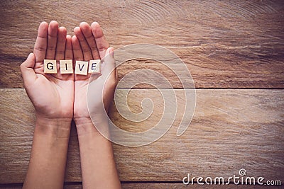 The word & x22;GIVE& x22; in hands in cupped shape. Concepts of sharing, g Stock Photo