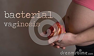 Words BACTERIAL VAGINOSIS. Young pregnant between 30 and 35 years old woman keeps rose blossom close to her belly in the Stock Photo