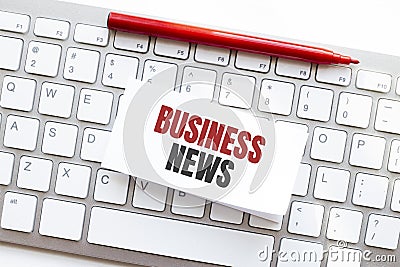 Words BUSINESS NEWS written on torn paper on a computer keyboard Stock Photo