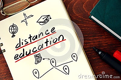 Words distance education written in the notepad. Stock Photo