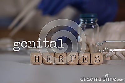 Words GENITAL HERPES composed of wooden dices. Pills, documents and a pen in the background Stock Photo