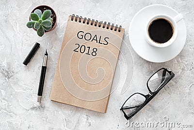 Words Goals for 2018 writting in notebook near glasses and cup of coffee on grey stone background top view mockup Stock Photo