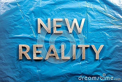 The words new reality laid with white letters over crumpled blue plastic film background Stock Photo