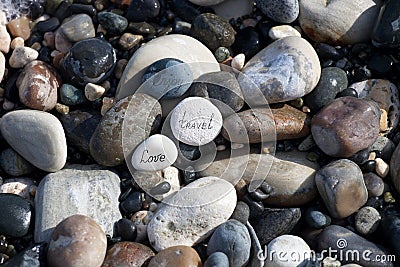 Words on pebble stones â€“ motivational concept slogan â€“ words love, travel, enjoy Stock Photo