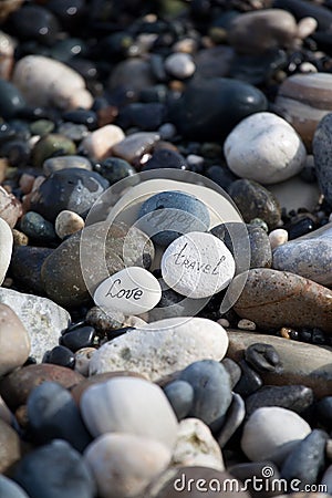 Words on pebble stones motivational concept slogan â€“ words love, travel, enjoy Stock Photo