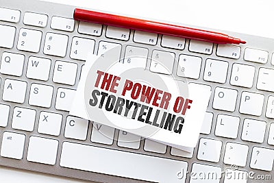 Words THE POWER OF STORYTELLING written on torn paper on a computer keyboard Stock Photo
