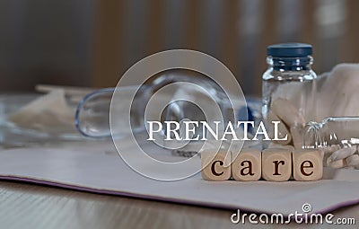 Words PRENATAL CARE composed of wooden dices. Pills, documents and a pen in the background Stock Photo