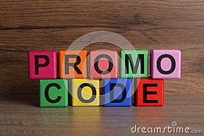 Words Promo Code made of colorful cubes with letters on wooden table Stock Photo