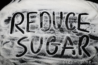 Words Reduce Sugar written in and with sugar grains, capital let Stock Photo