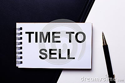 The words TIME TO SELL written in red on a black and white background near the pen Stock Photo