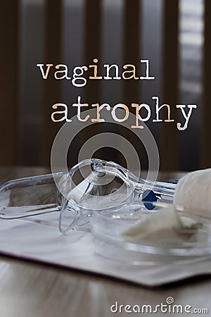 Words VAGINAL ATROPHY. Plastic vaginal speculum, pills and other tools in the background Stock Photo