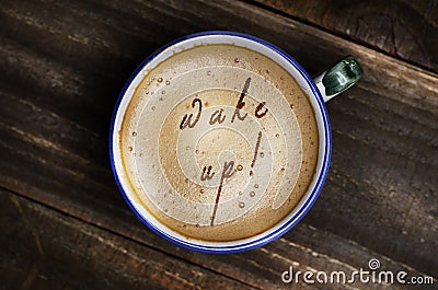 Words wake up formed from coffee foam. Cup of cappuccino coffee Stock Photo