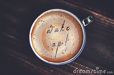 Words wake up formed from coffee foam. Cup of cappuccino coffee Stock Photo
