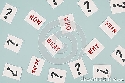 The words who what where how why and when are standing on small pieces of paper, question marks, asking for solution Stock Photo