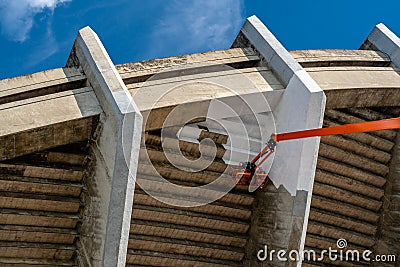 Worier in Bucket of the Big Crane Vehicle Cleaning and Painting Building Stock Photo