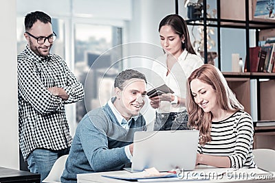 Calm occupied company working and using the laptop. Stock Photo