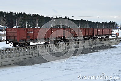 Unloading of crushed stone a railway car of a dump truck, closeup. Unloading bulk cargo from railway wagons Editorial Stock Photo