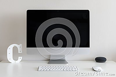 Work desk with a computer and the letter C against a white wall Editorial Stock Photo