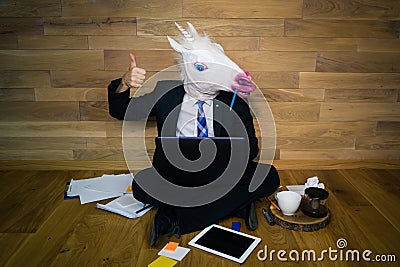 Work is done! Unicorn in a suit and tie smiles and shows thumb up. Stock Photo