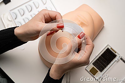 Work on the eyelash extensions on a mannequin, putting the strip under the eye. Training eyelash extensions. Stock Photo