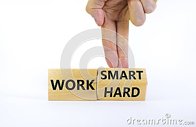 Work hard or smart symbol. Businessman turns wooden block and changes words `work hard` to `work smart`. Beautiful white Stock Photo