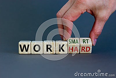 Work hard or smart symbol. Businessman turns wooden cubes and changes words `work hard` to `work smart`. Beautiful grey backgr Stock Photo