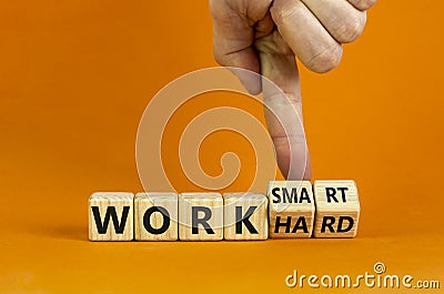 Work hard or smart symbol. Businessman turns wooden cubes and changes words `work hard` to `work smart`. Beautiful orange Stock Photo