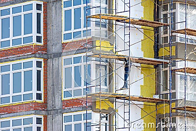 work at height to insulate the walls of a residential building using scaffolding Stock Photo