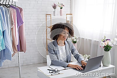 Work at home during covid-19 quarantine. Happy african american woman typing in laptop Stock Photo