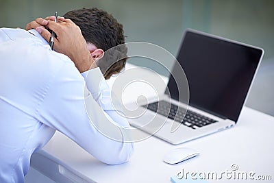 When work just becomes too much...an upset-looking businessman in an office. Stock Photo