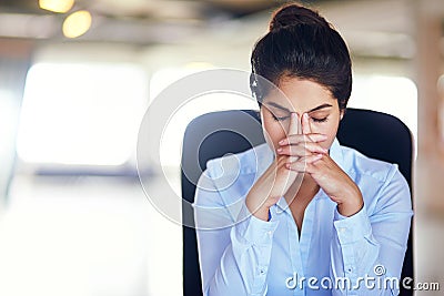 When work just becomes too much...a young businesswoman looking stressed while sitting in her office chair. Stock Photo
