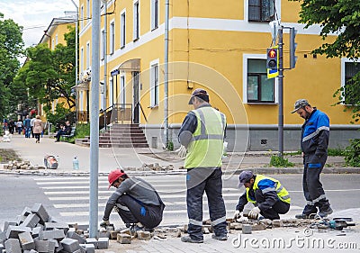 Work on laying the new tile on a city street. Lays the new tile on the floor. Paving in the city. Urban landscaping. Russia. Gatch Editorial Stock Photo