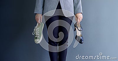 Work Life Balance Concept, present by Business Working Woman holding a High Heal and Sneaker Shoes, Croped image with Copy Space Stock Photo