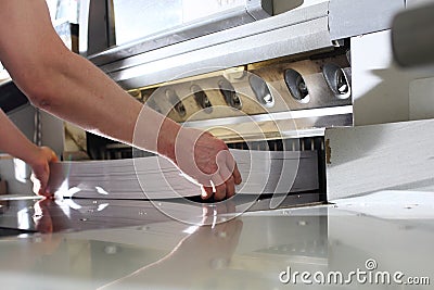 Bindery. Paper trimming on a guillotine. Cutter for cutting paper. Printing house Stock Photo