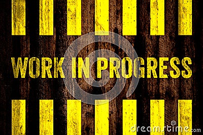 Work in progress warning sign with yellow and black stripes painted over cement concrete wall coarse surface texture background. Stock Photo