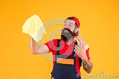 Work quickly to get house looking spotless and feeling fresh. Man brutal cheerful bearded worker wiping dust rag Stock Photo