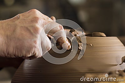Work with red clay. Male hands form a bowl on a spinning pottery wheel. Stock Photo