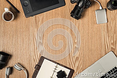 Work space for photographer, graphic designer. Flat lay of laptop, camera, colorchart, digital tablet, coffee cup, book, pencil o Stock Photo