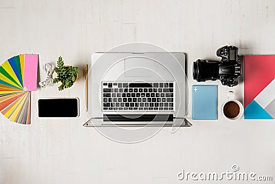 Work space for photographer, graphic designer. Flat lay of laptop, camera, colorchart, digital tablet, coffee cup, book, pencil o Stock Photo