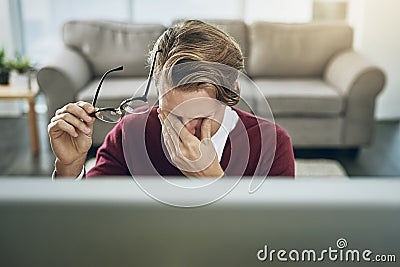 Work stress - the struggle is real. a young man suffering from stress while using a computer at his work desk. Stock Photo