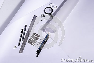 Work table of an architect with blank paper, magnifying glass, ruler, pencils, pens and clips. Architect ready to start work. In b Stock Photo