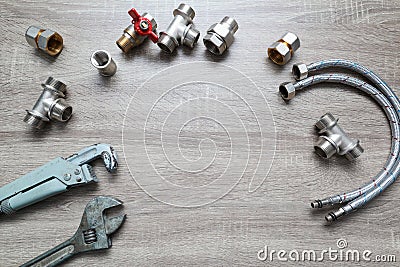 Plumbing concept set of piping accessories plumb adjustable wrenches fittings on wooden background. Plumbing tools and equipment Stock Photo
