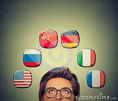 Work and travel opportunity concept. Woman in glasses looking up at icons of international flags Stock Photo