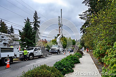Work trucks and crews installing 5G, new technology, wireless communications cell site Editorial Stock Photo