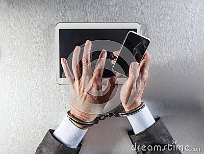 Workaholic businessman tied to communications handcuffs using mobile technology Stock Photo