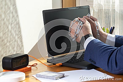 Workaholic entrepreneur`s hands trapped in chains spending time doing nothing telecommuting Stock Photo